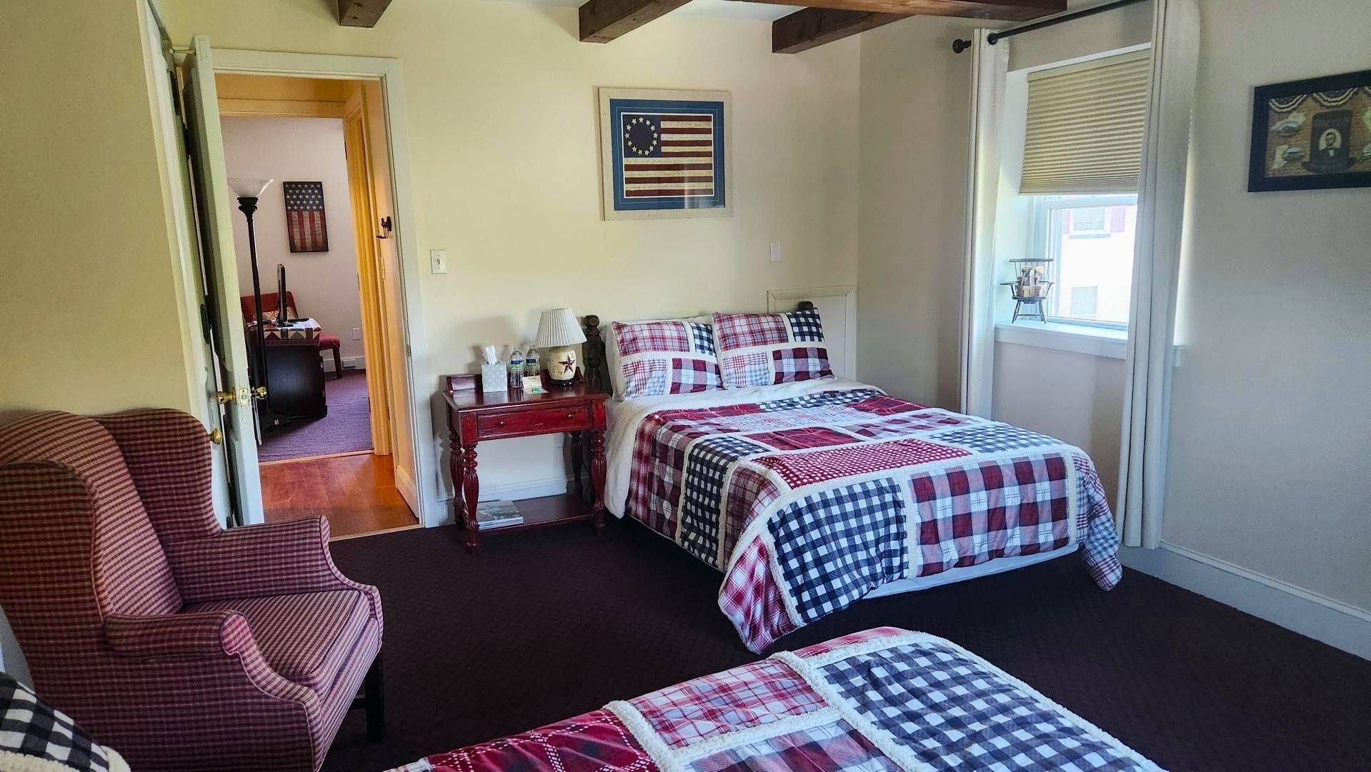 There are two beds and a chair in the room.