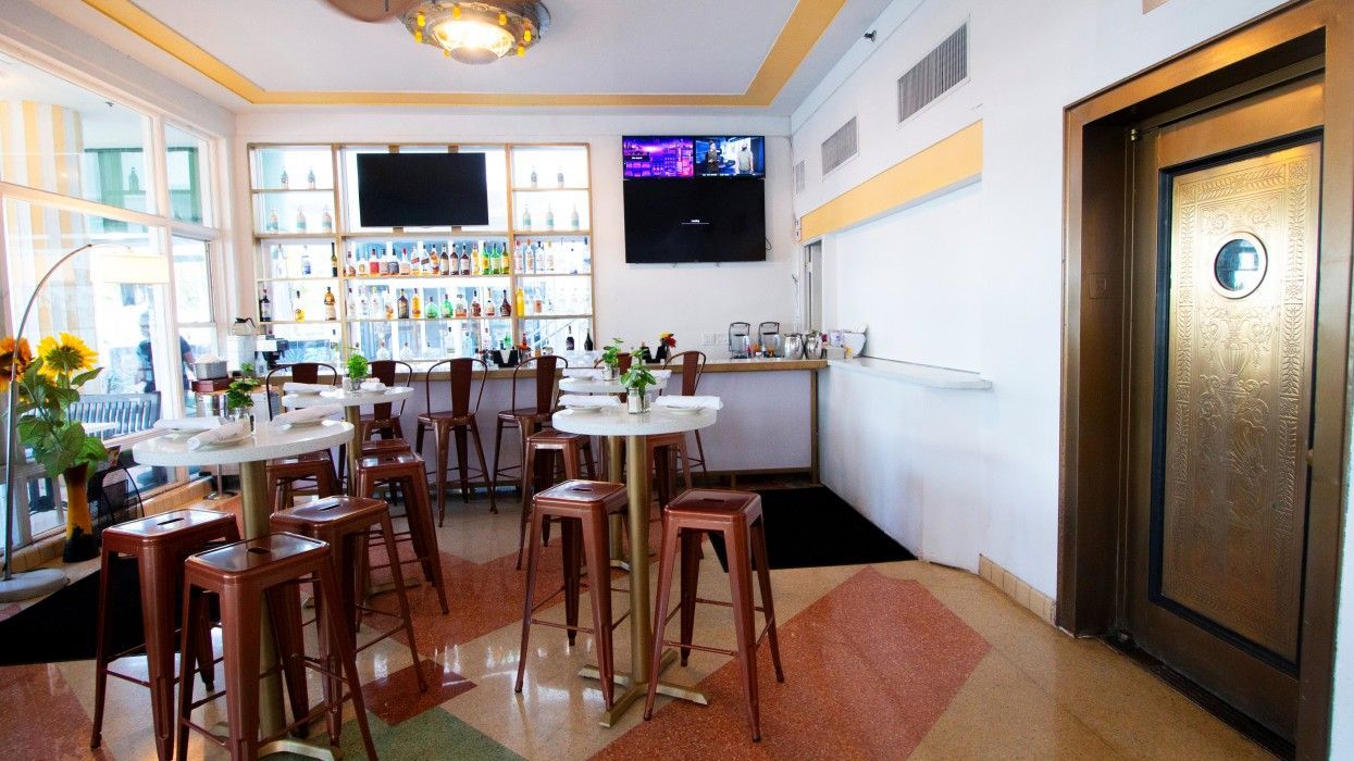 A restaurant with tables and stools and a bar