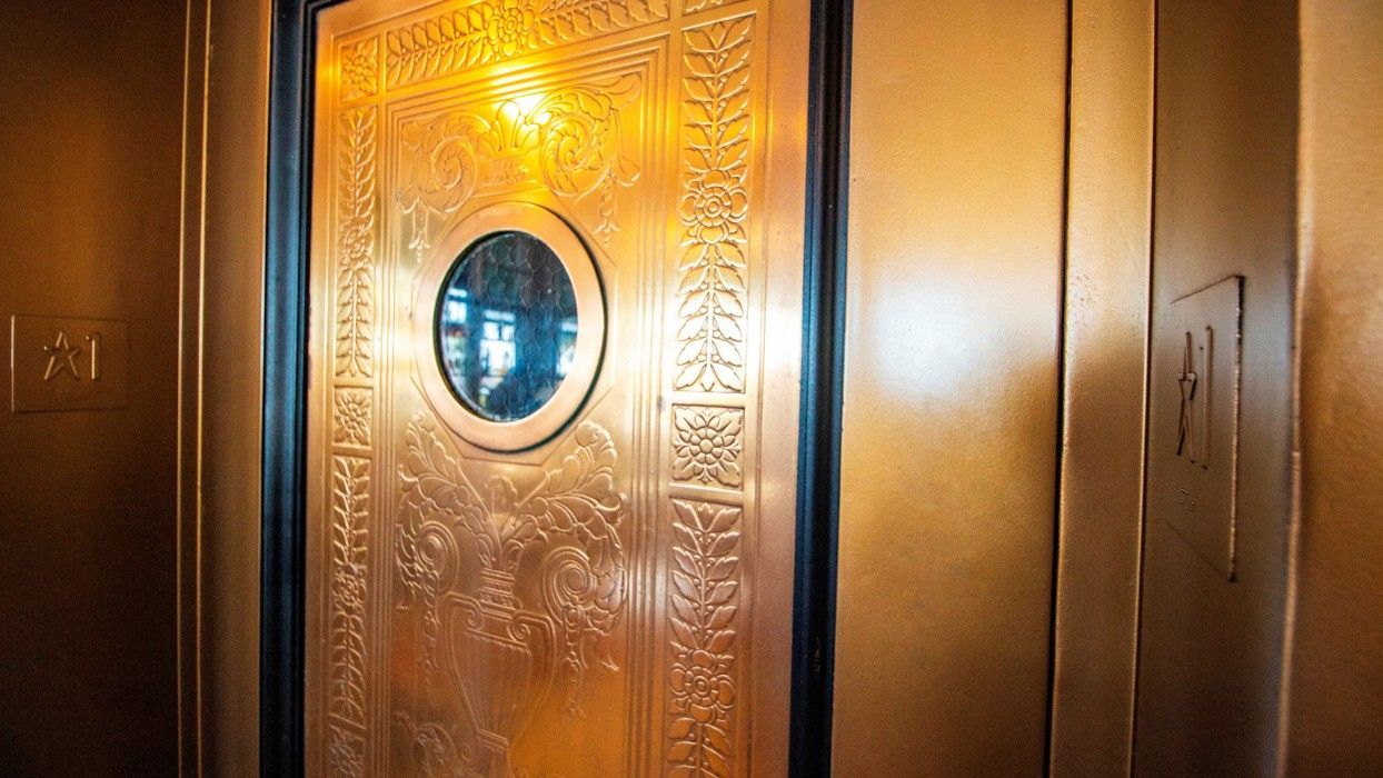 A close up of a door in an elevator with a round window.