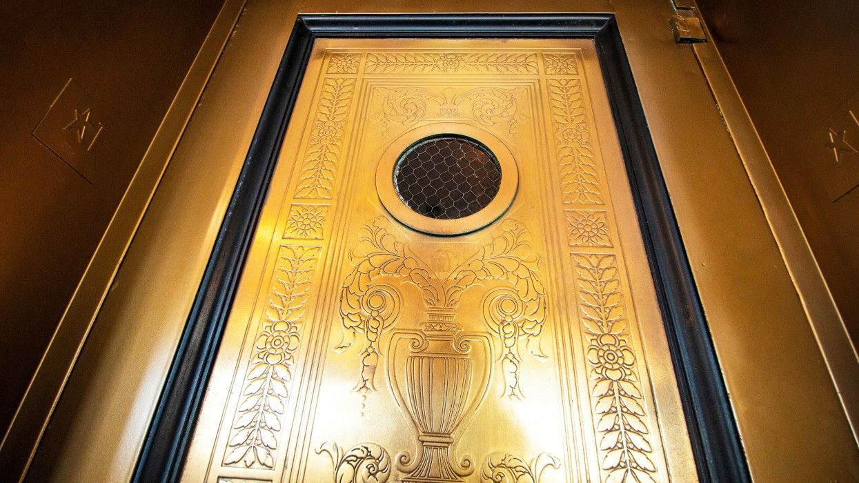 A gold door with a circular hole in the middle of it.