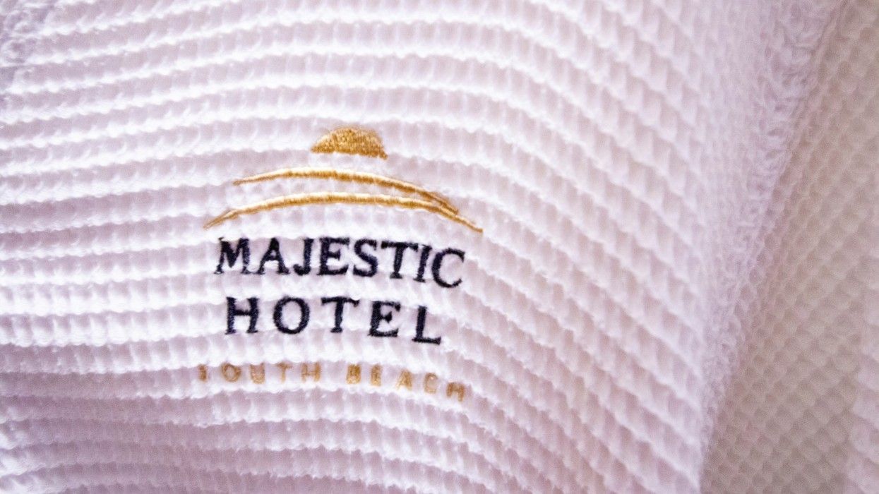 A white robe with the words majestic hotel south beach embroidered on it.