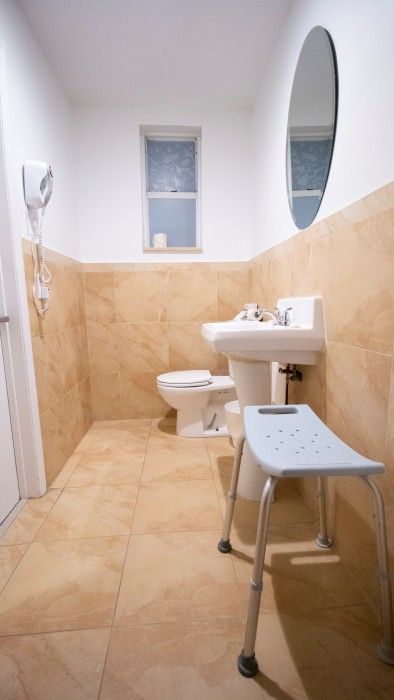 A bathroom with a toilet , sink , and mirror.