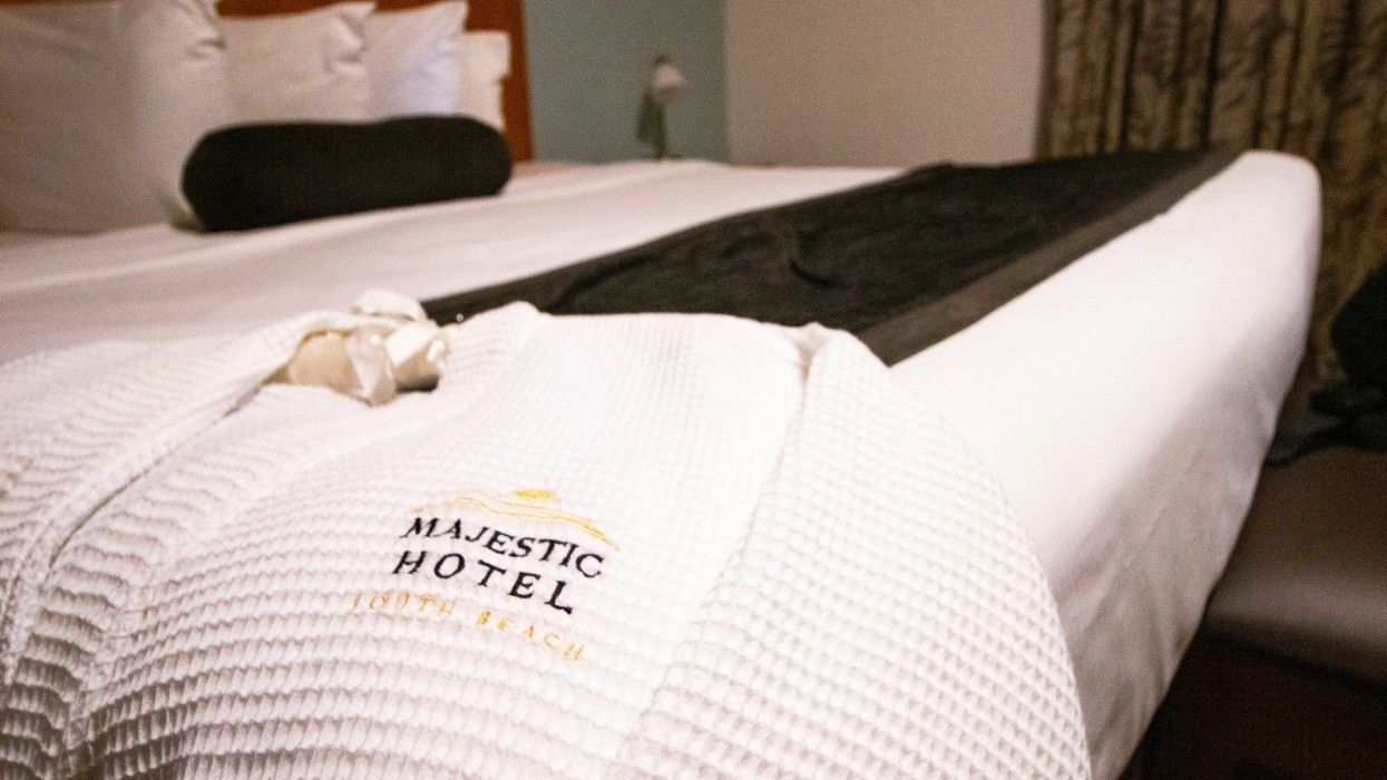 A bed with a robe that says majestic hotel on it