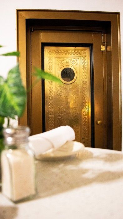 A bathroom with a gold door and a bottle of salt on the counter.