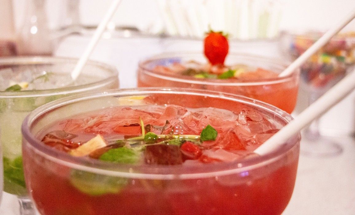 A close up of three bowls of drinks with straws on a table.