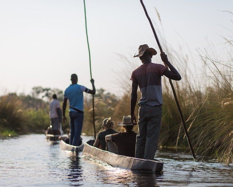 en gruppe mennesker roer både ned ad en flod