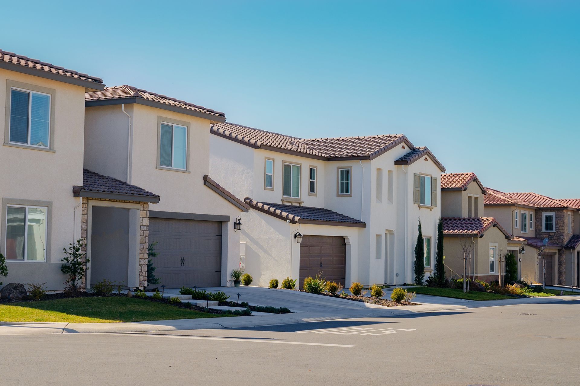 A row of houses in a residential area with a blue sky in the background.