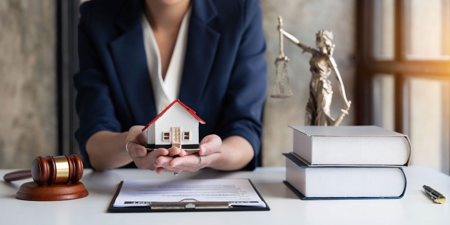 female lawyer holding a house figurine, property insurance and security concept