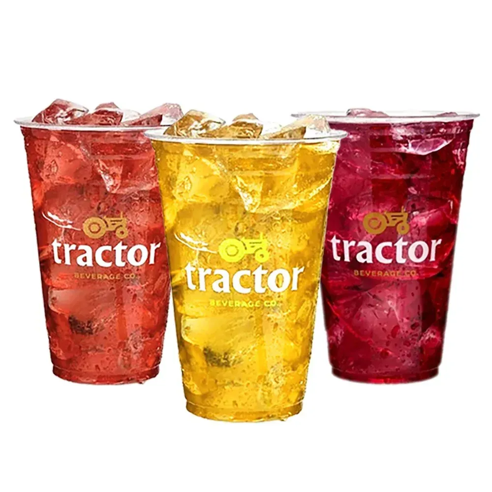 Three cups of Tractor Beverages: red, yellow, and purple drinks with ice, featuring the logo on each.