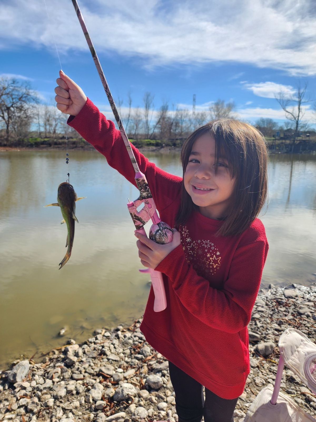 Child catching fish in pond at Long Creek RV Park New Braunfels TX