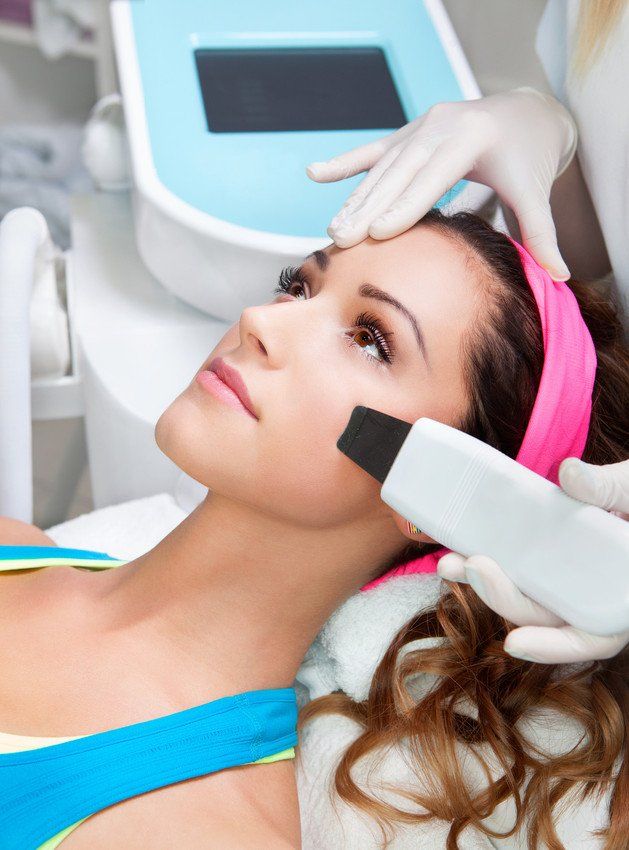 Woman getting ultrasound skin cleaning at beauty salon