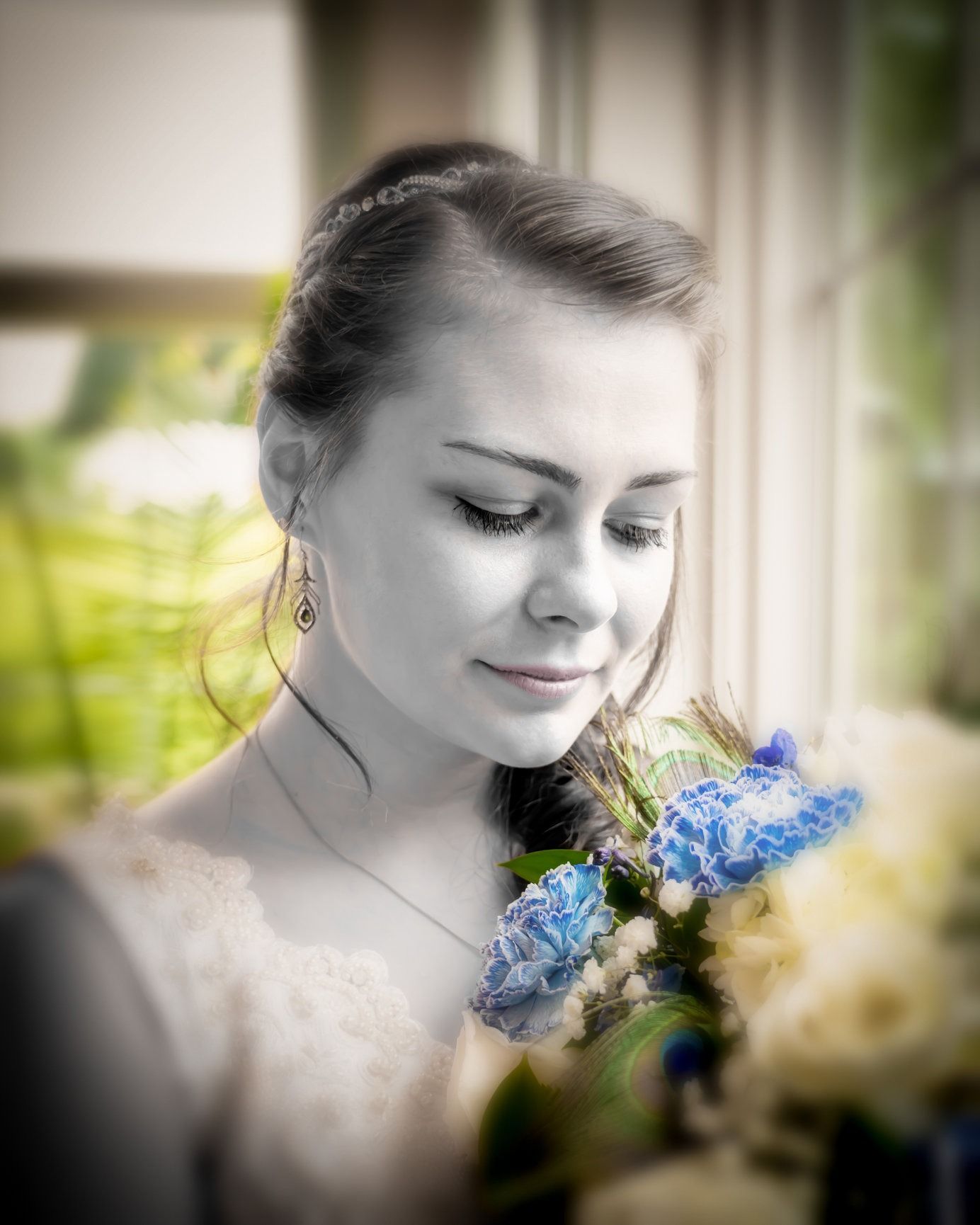 Woman with flowers, looking down pensively. Blue flowers and selective color.
