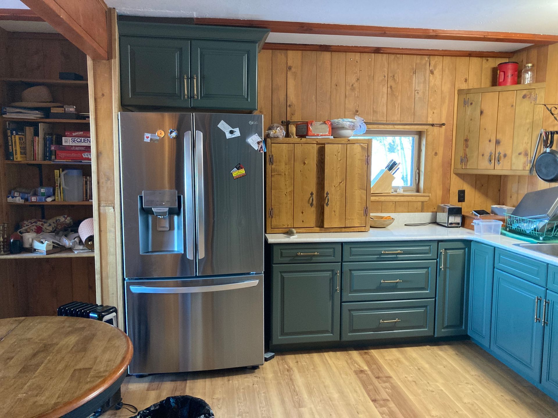 A kitchen with a stainless steel refrigerator and blue cabinets