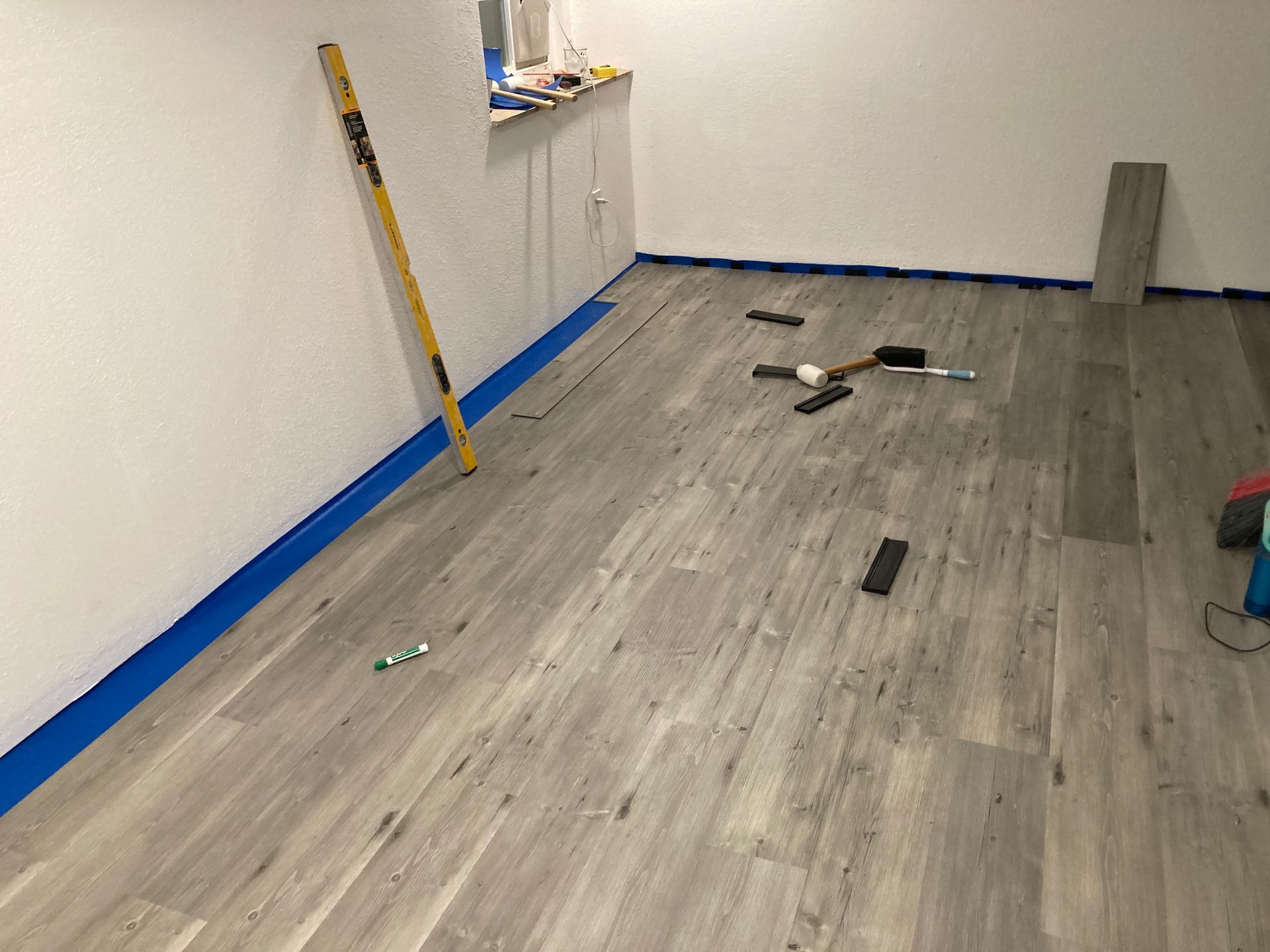 A room with a wooden floor and a level on the floor.