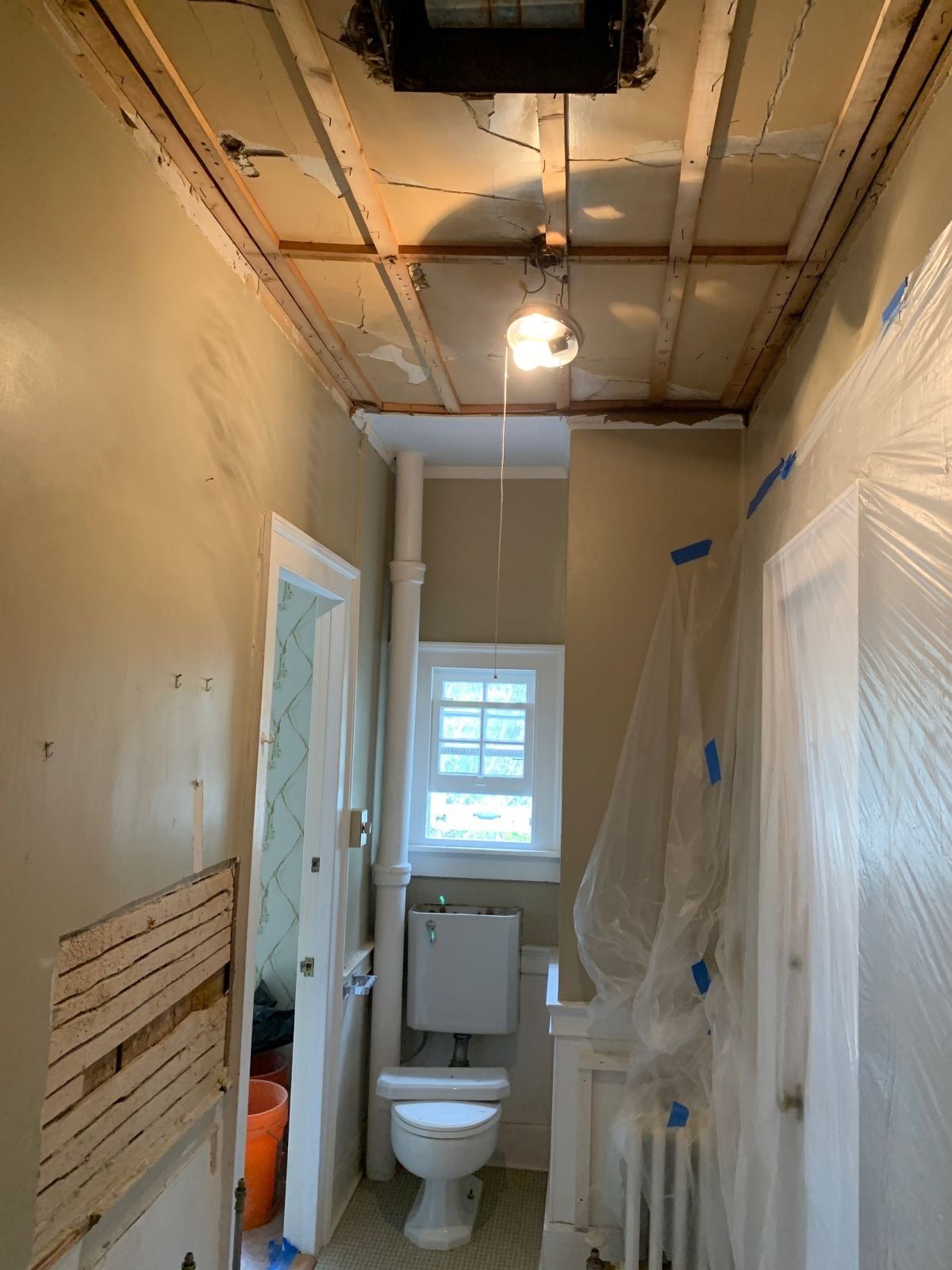A bathroom with a toilet , sink , and window.