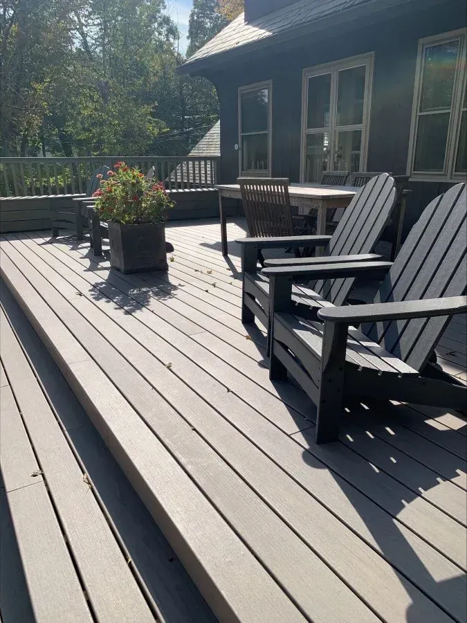 A deck with chairs and a potted plant on it