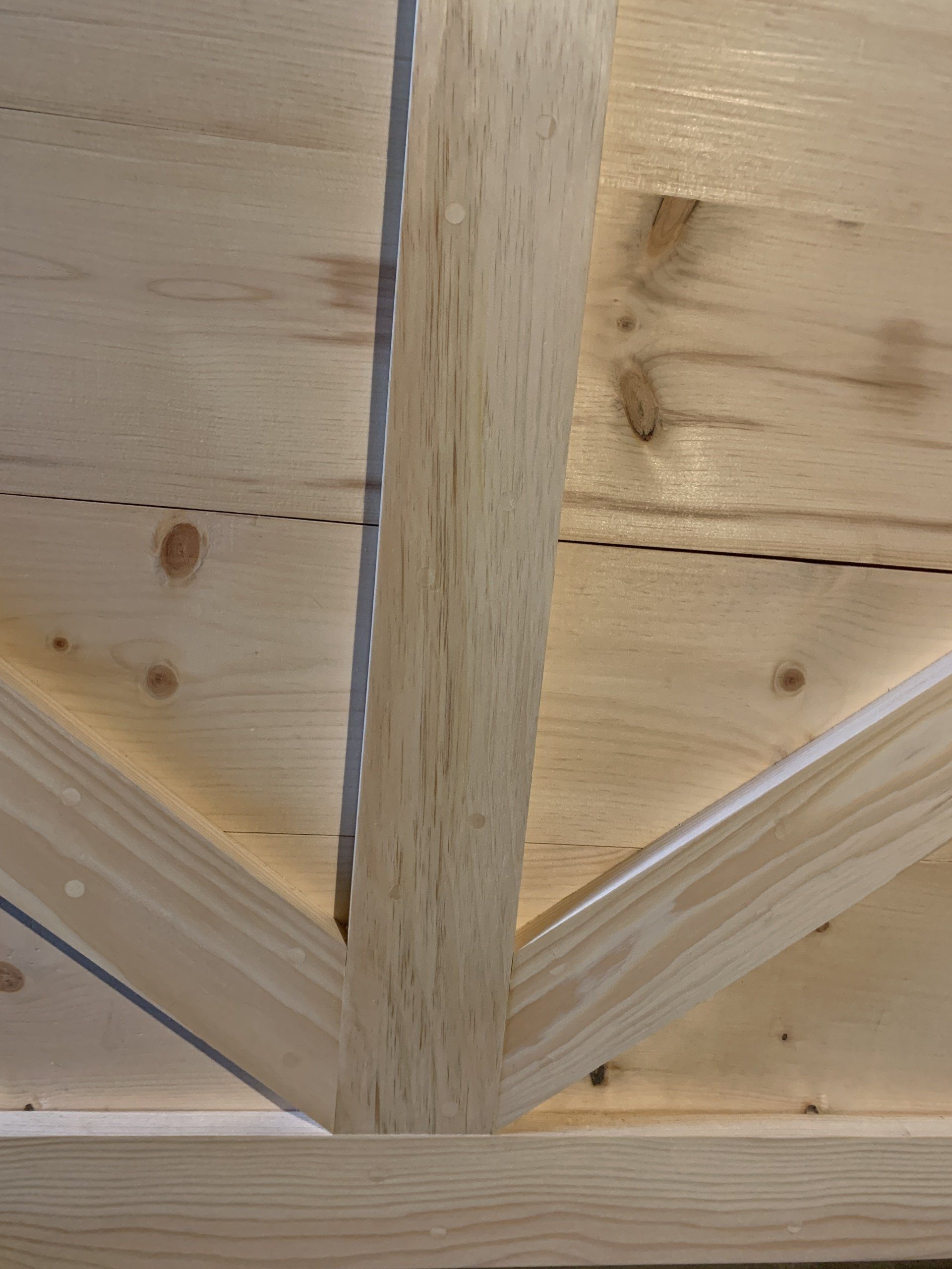A close up of a wooden structure with a metal beam