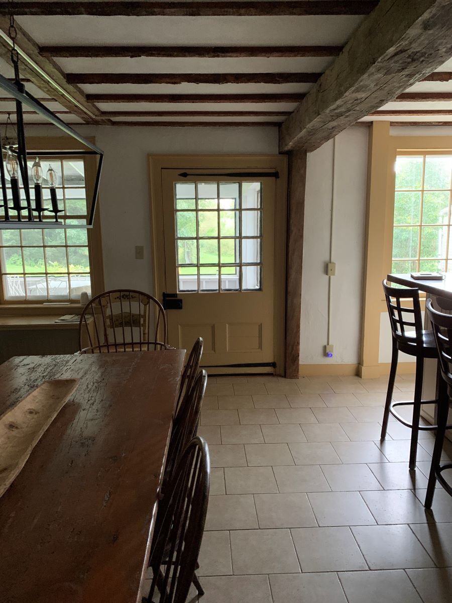 A dining room with a table and chairs and a door.