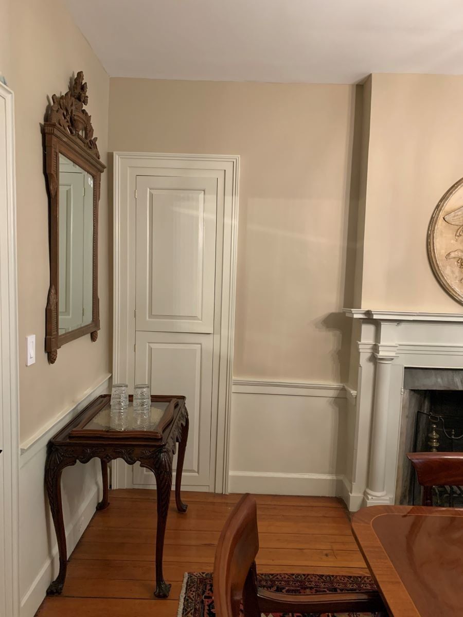 A dining room with a table , chairs , fireplace and mirror.