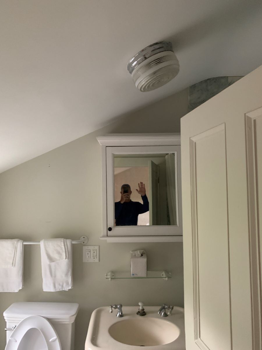 A bathroom with a toilet a sink and a mirror