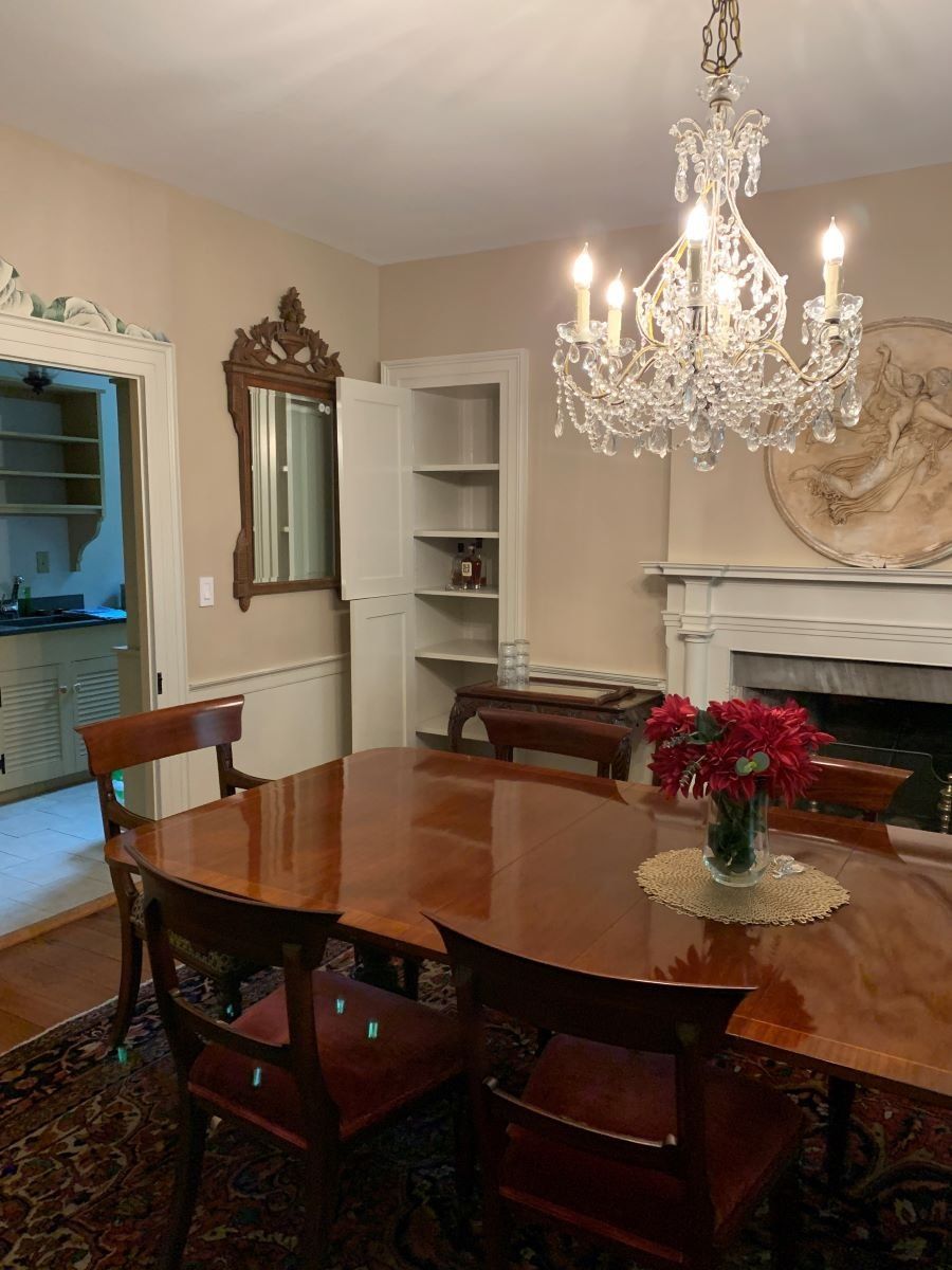A dining room with a table and chairs and a chandelier