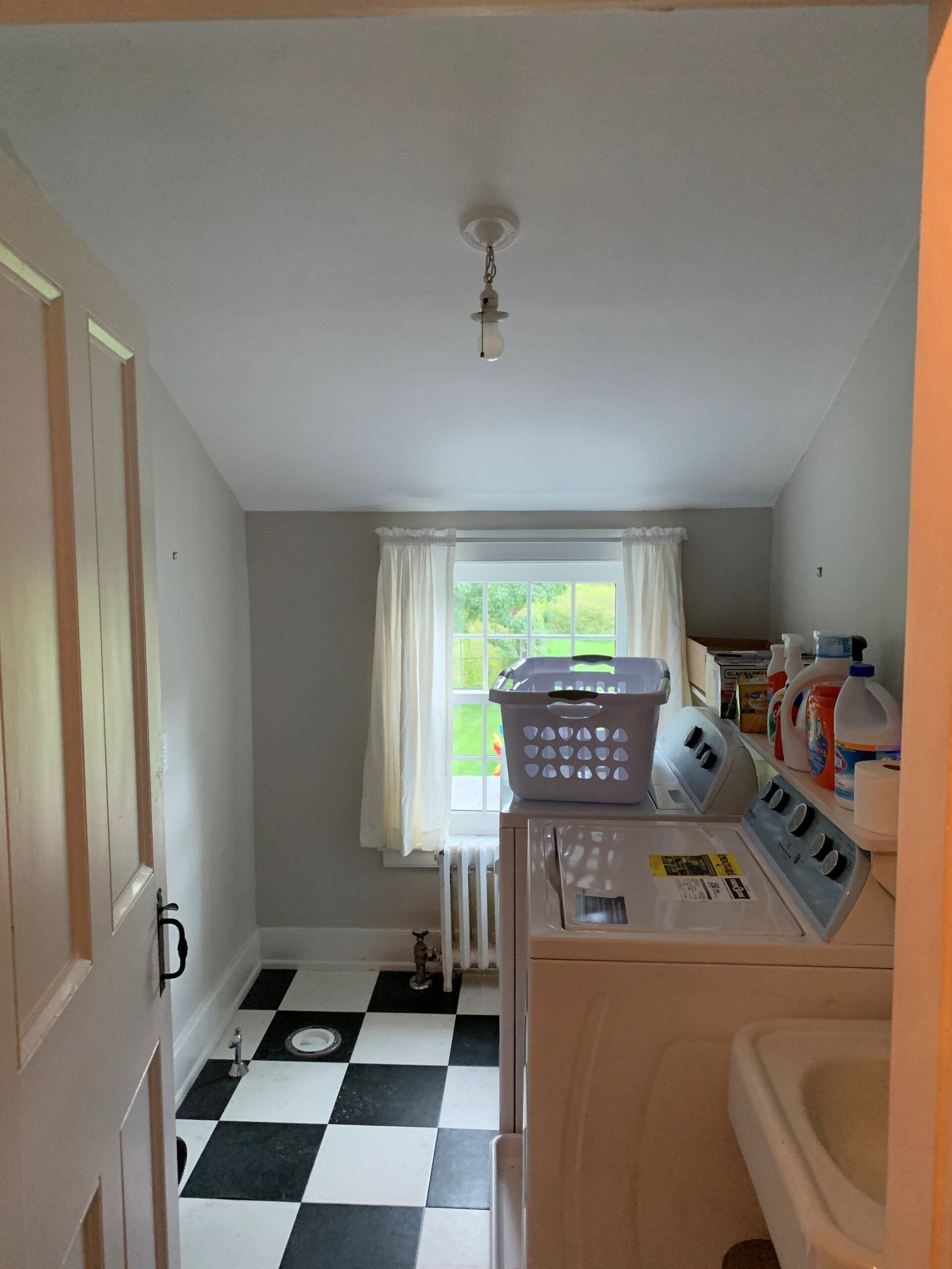 A laundry room with a black and white checkered floor
