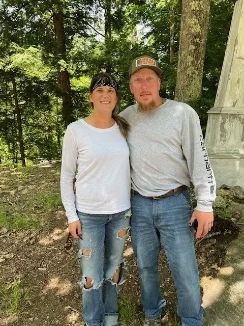 A man in a kitchen with a sign above him that says food and friends