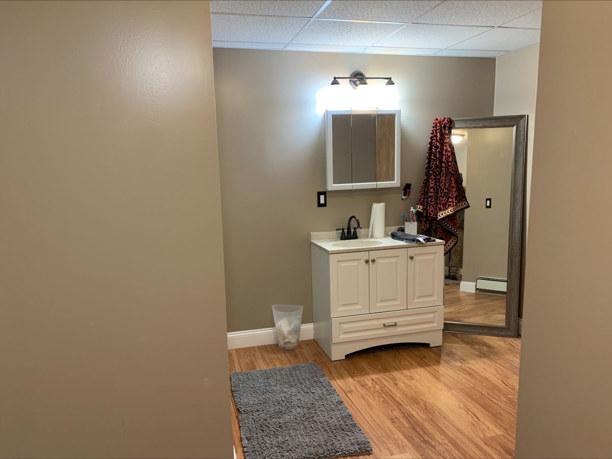 A bathroom with a sink , mirror and rug