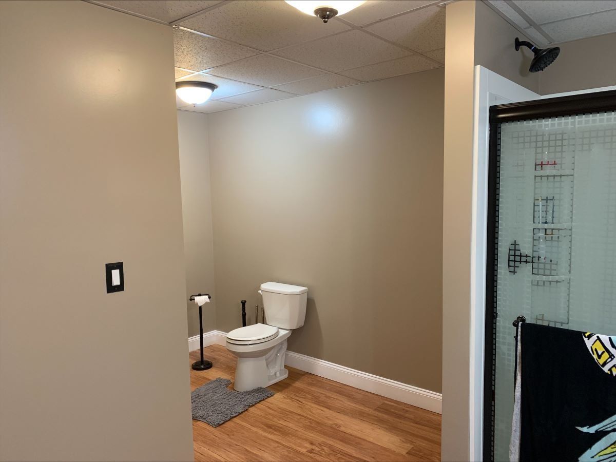 A bathroom with a toilet and a shower.