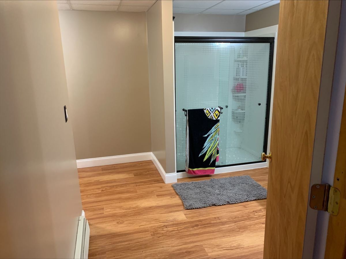 A bathroom with a sliding glass door and a rug on the floor.
