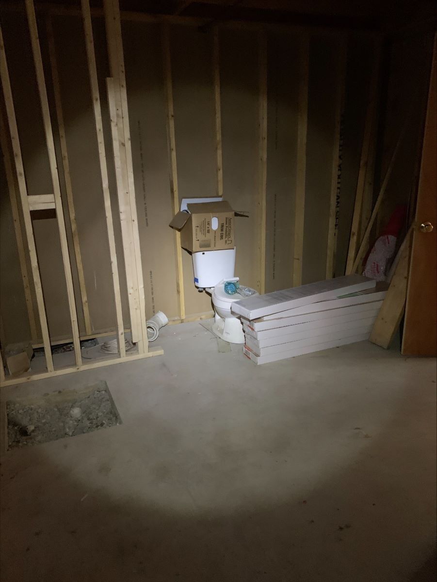 A bathroom under construction with a toilet and bathtub.