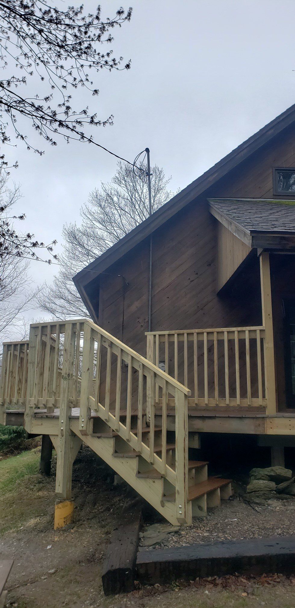 A house with a wooden deck and stairs leading up to it.