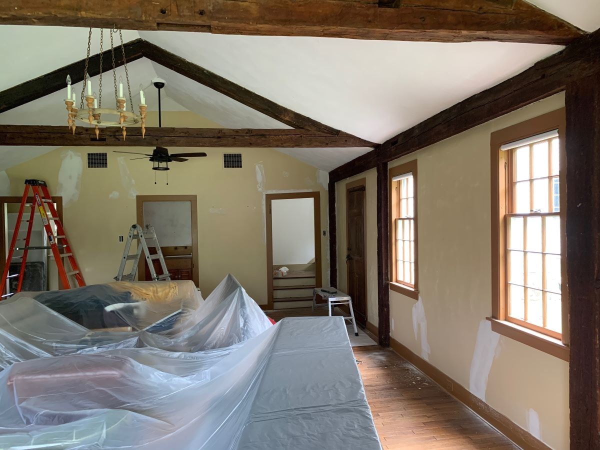 An empty room with a ceiling fan and a ladder