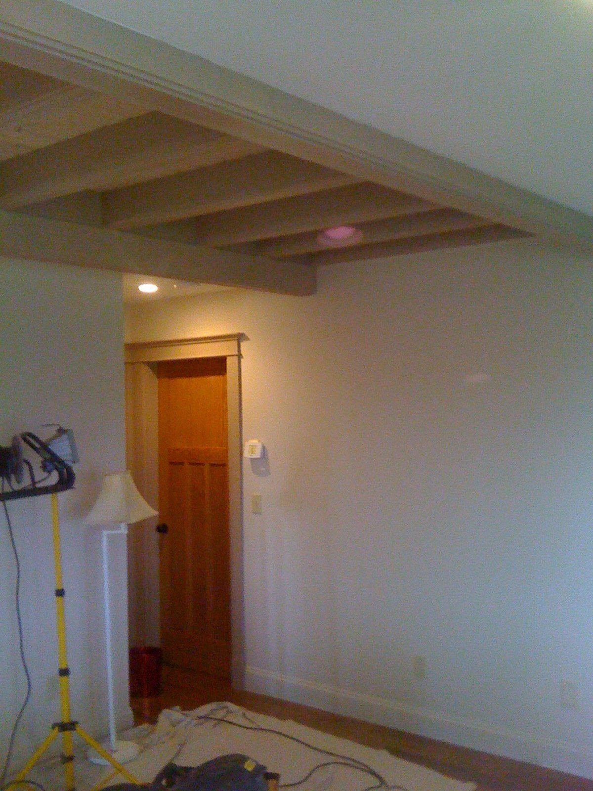 A room with white walls and wooden beams on the ceiling