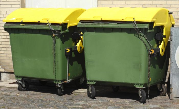 two green garbage dumpsters