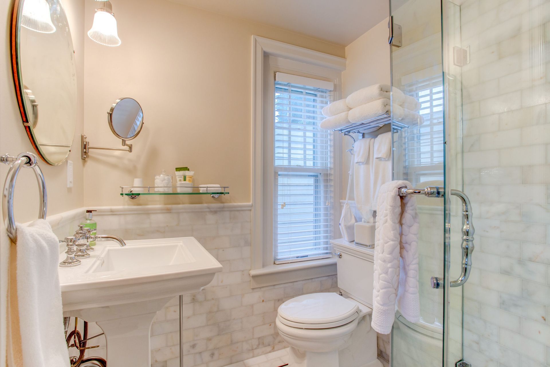 A bathroom with a toilet , sink , mirror and shower.