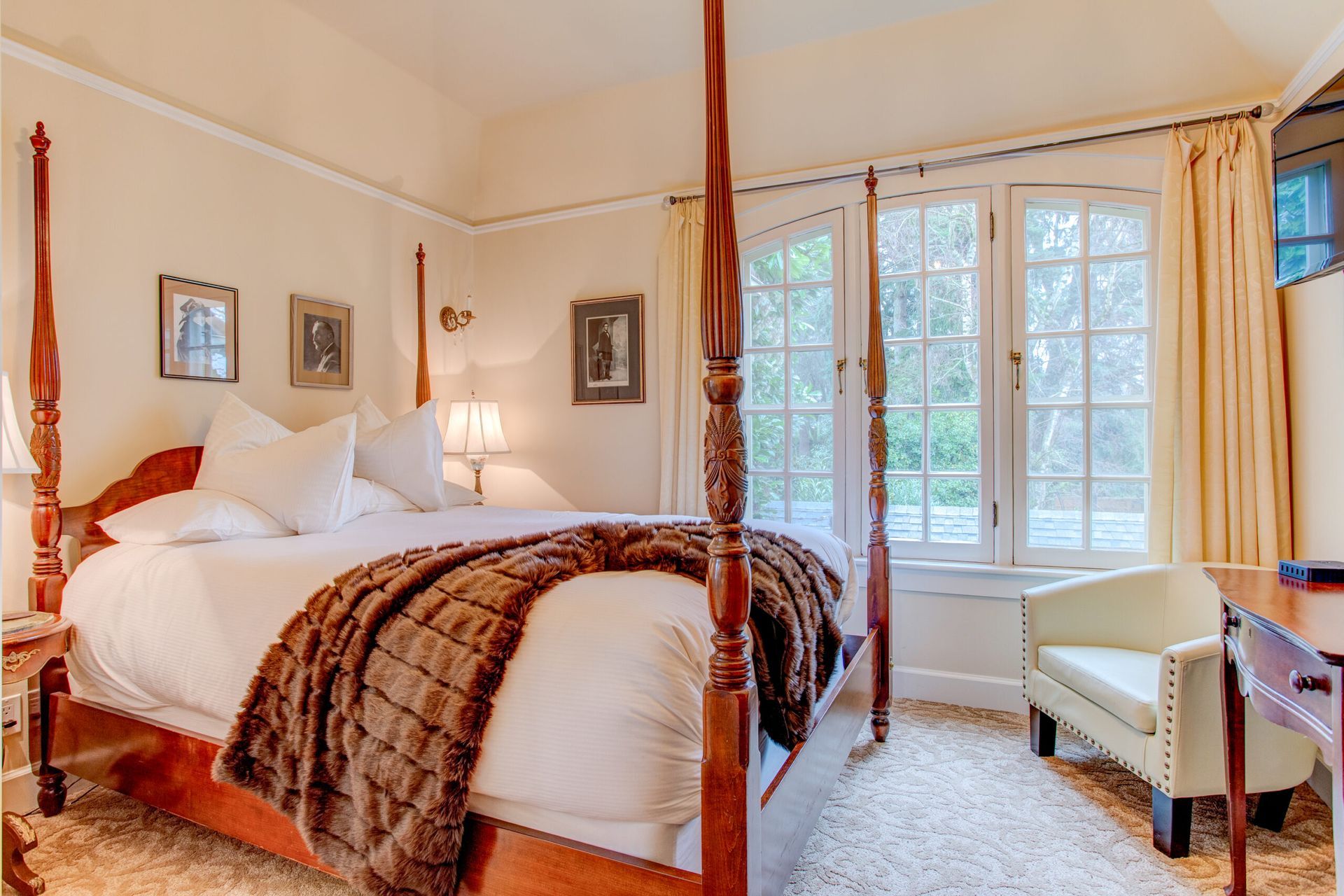 A bedroom with a four poster bed and a chair