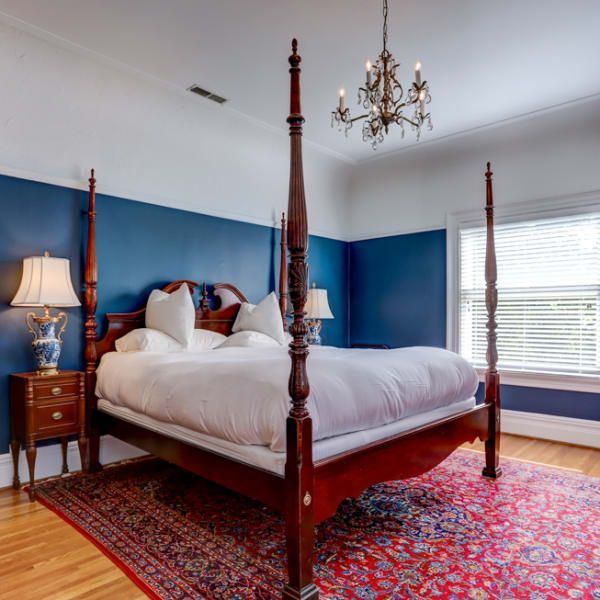 A four poster bed in a bedroom with blue walls