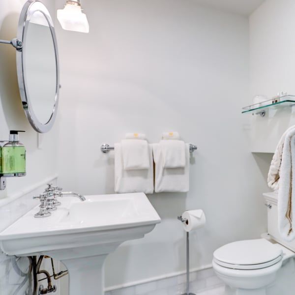 A bathroom with a sink toilet and mirror