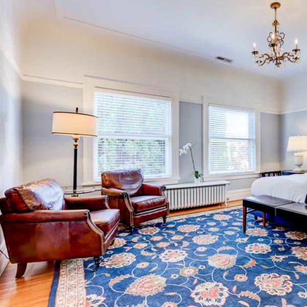 A living room with a blue rug and two chairs