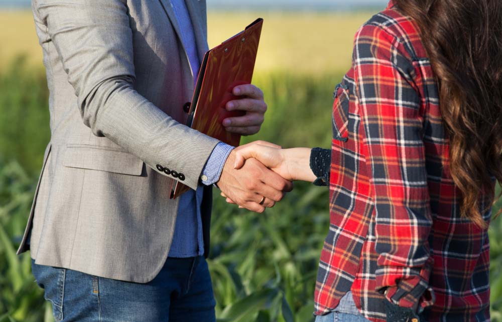 Farmer woman shaking hands with business man — Insurance Services in Mackay QLD