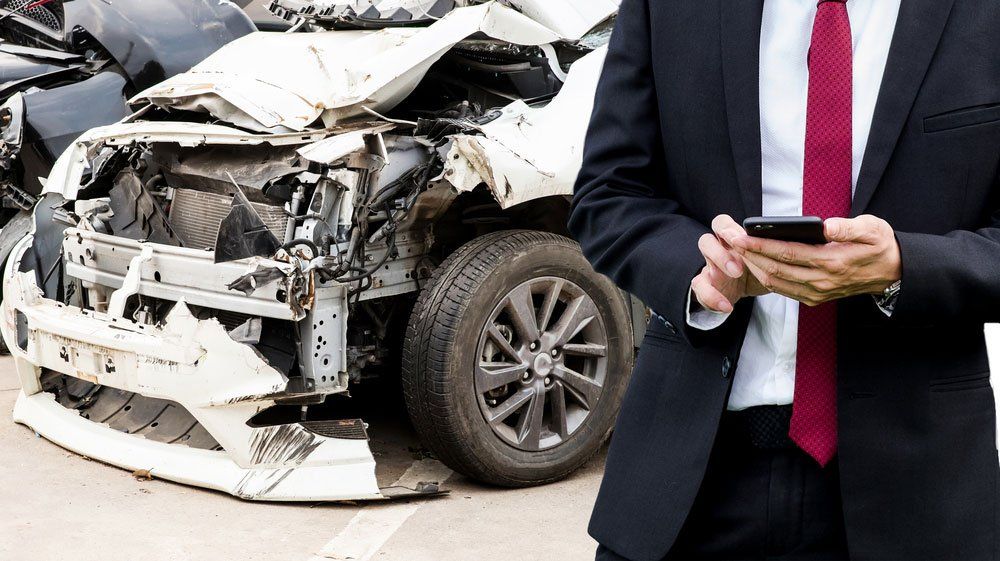 Male insurance agent examining car after accident — Insurance Services in Mackay QLD