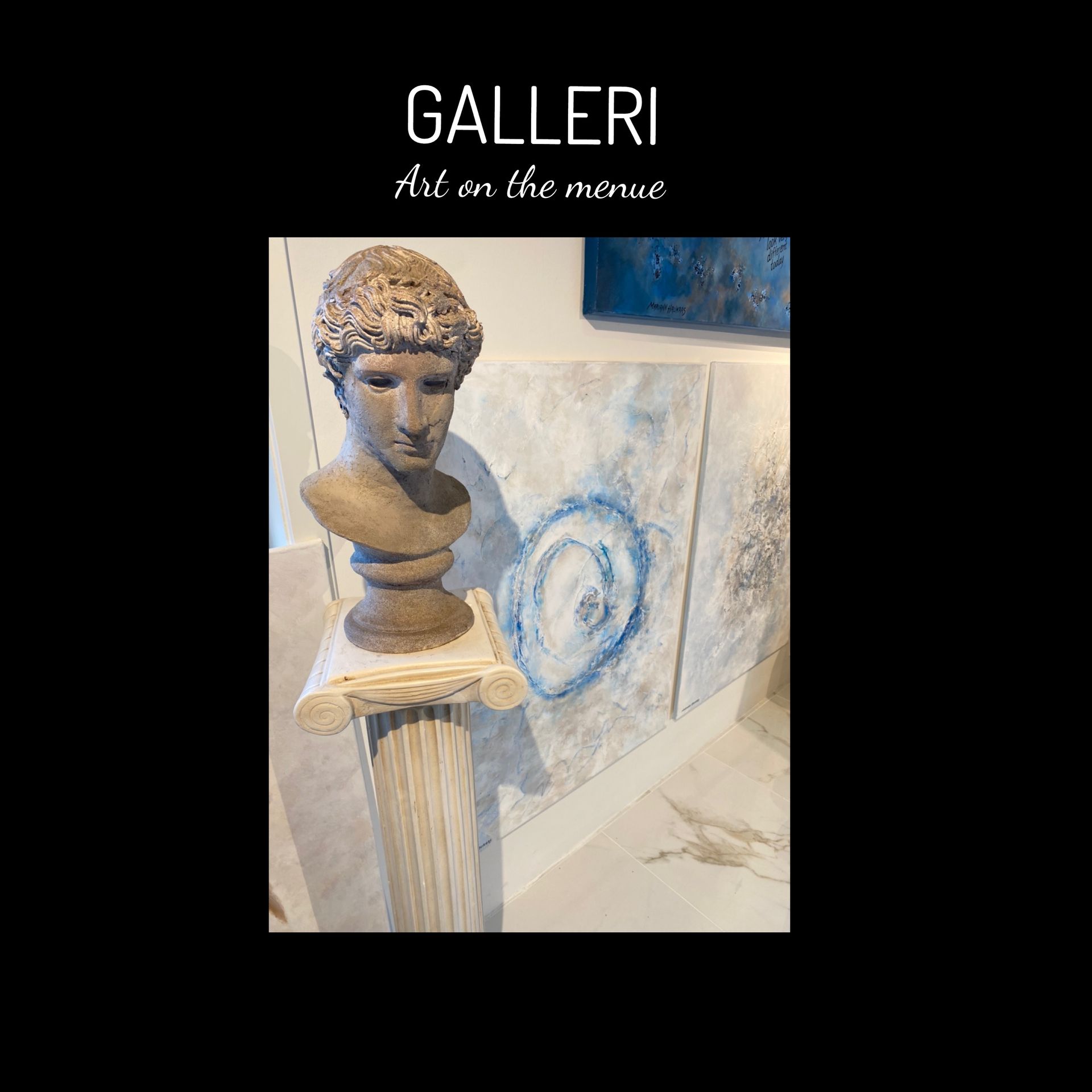 A statue of a man 's head is on a pedestal in a gallery.