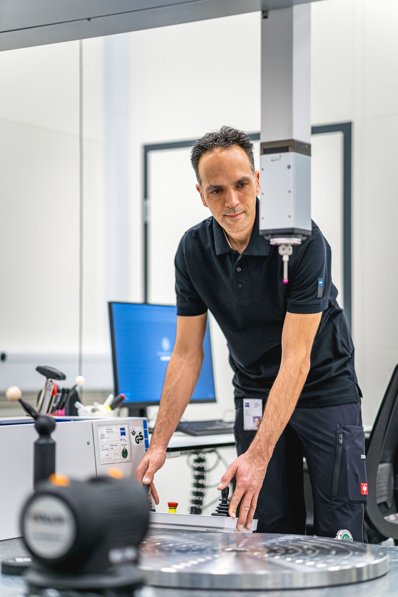 A man is standing in front of a machine in a lab.