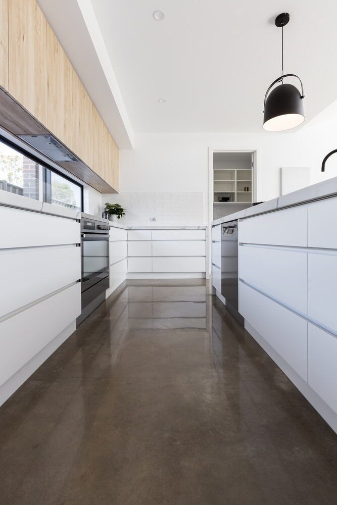 Modern White Kitchen With Wood Cabinets, a Dark Floor, and a Black Pendant Light — Colour Splash in Nelson Bay, NSW