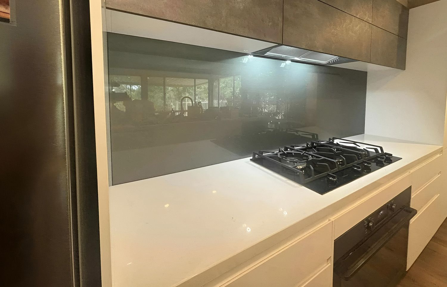 Modern Kitchen With White Countertops And Dark Gray Backsplash