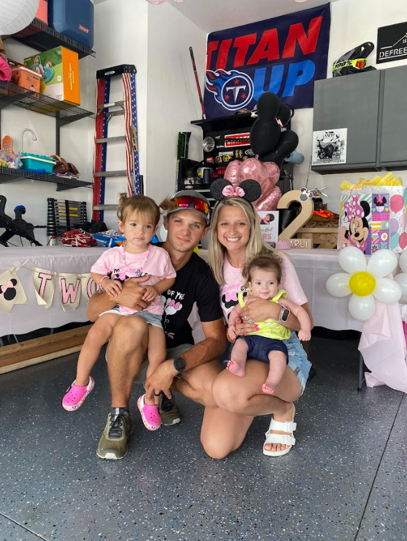 A white house with a covered porch and a large lawn in front of it.