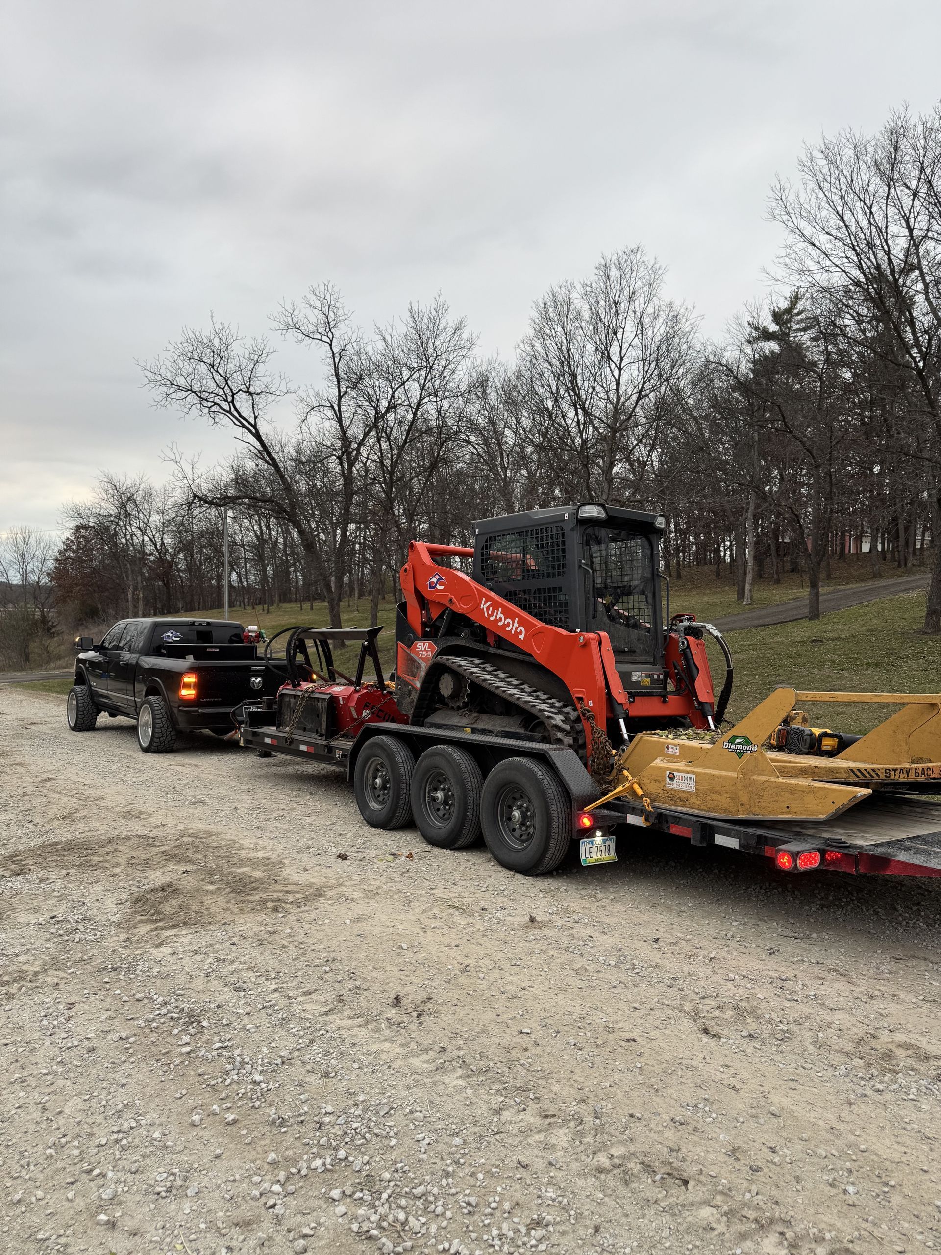 A truck is towing a bulldozer on a trailer.