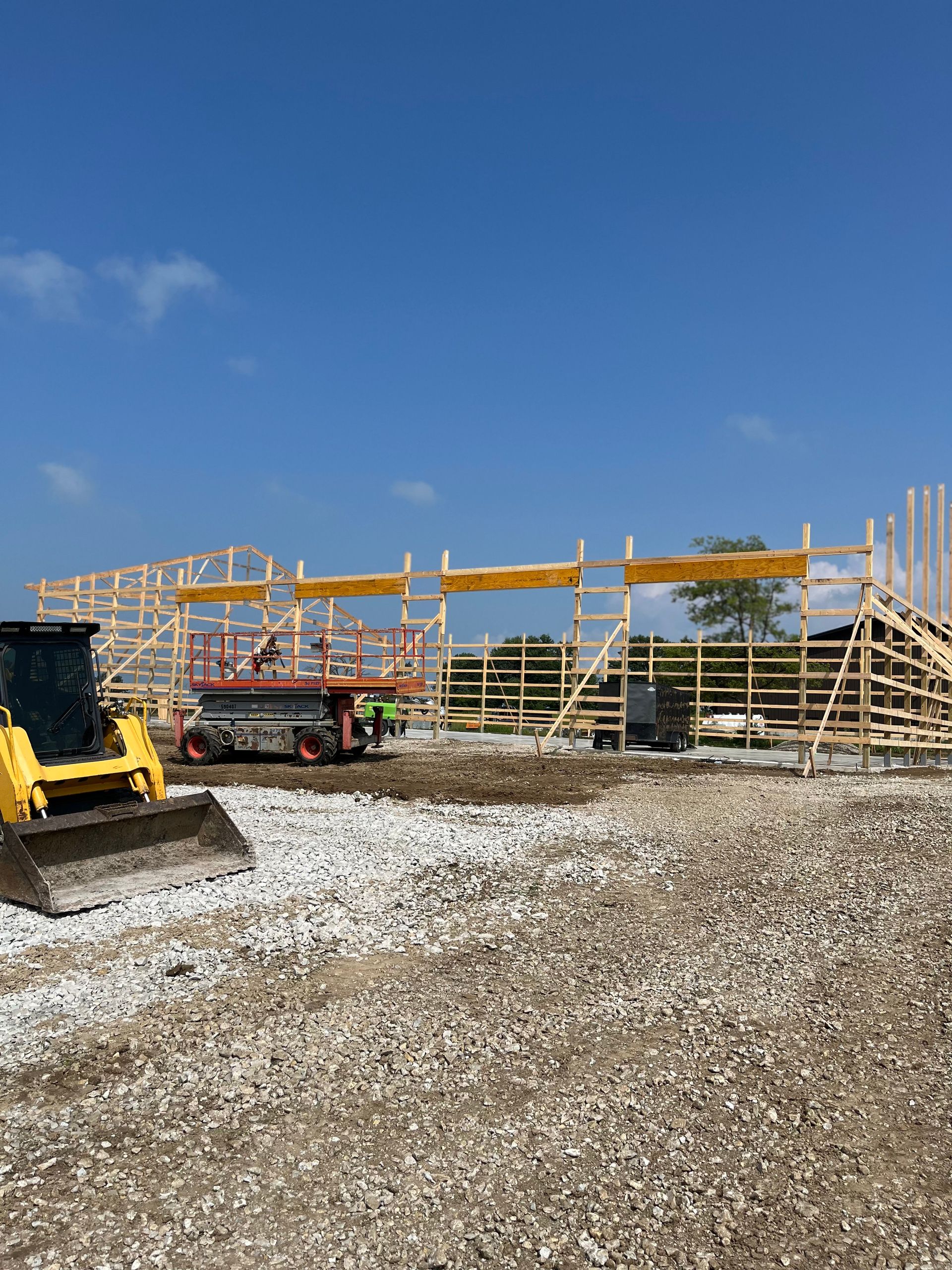 A bulldozer is parked in front of a building under construction.