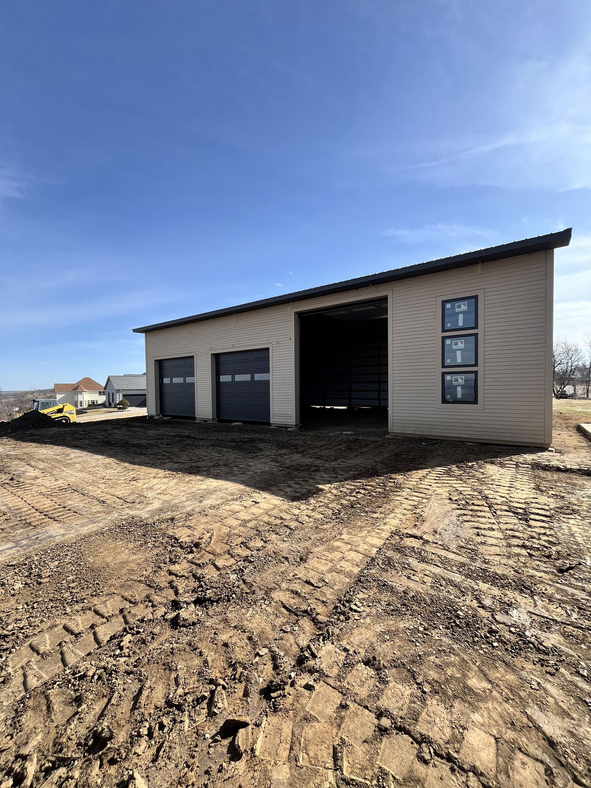 A garage is being built in the middle of a dirt field.